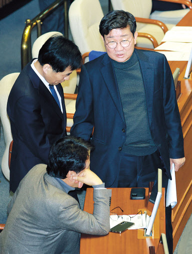 전해철 더불어민주당 의원이 김민기 의원, 안민석 의원과 지난달 29일 열린 국회 본회의에서 대화하고 있다. [연합]