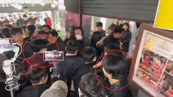 지난 7일 수원 지동못골시장에서 시민들과 인사를 나누는 한동훈 국민의힘 비대위원장(왼쪽 원)을 지켜보는 주진우씨(오른쪽 원). [유튜브 캡처]