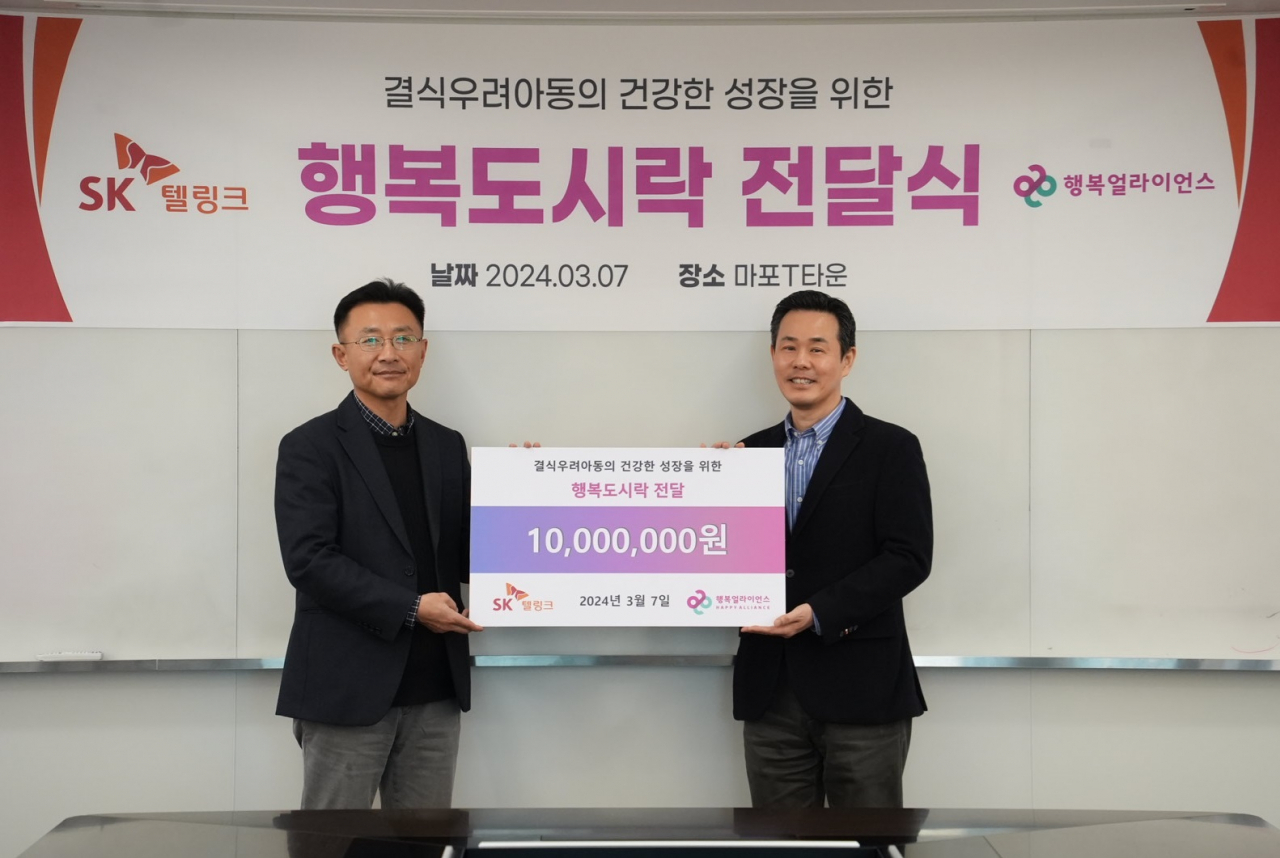 조민영(오른쪽) 행복얼라이언스 사무국 본부장, 김문겸 SK텔링크 경영지원본부 담당이 전달식에서 기념촬영을 하고 있다. [행복얼라이언스 제공]