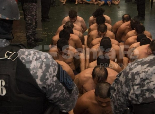 상의를 벗은 채 고개를 숙이고 앉아 있는 아르헨티나 재소자들[파블로 코코치오니 산타페주 법무부 장관 인스타그램 캡처]