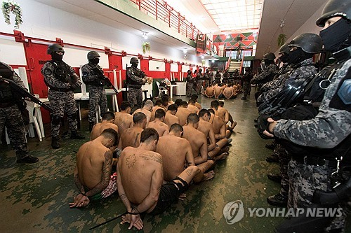 반바지만 입고 바닥에 앉아 있는 아르헨티나 재소자들[아르헨티나 산타페 주 정부 제공]
