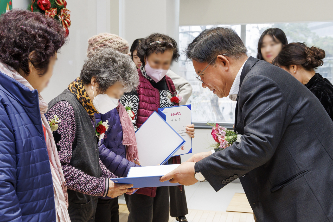 지난해 12월 열린 마포학교 종업식에서 박강수 마포구청장이 어르신에게 수료증을 전달하고 있다.[마포구 제공]