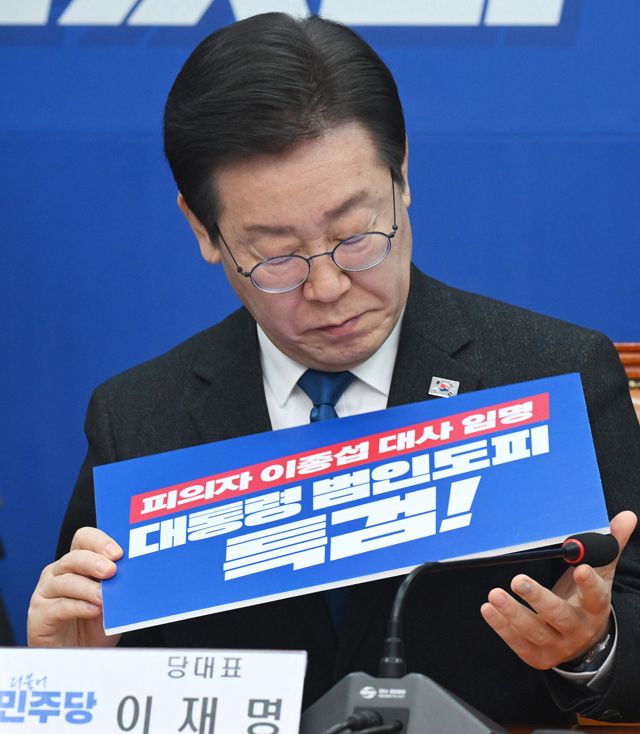이재명 더불어민주당 대표가 11일 서울 여의도 국회에서 열린 최고위원회의에 참석해 해병대 채상병 사건 관련 특검을 촉구하는 내용의 피켓을 살펴보고 있다. 이상섭 기자