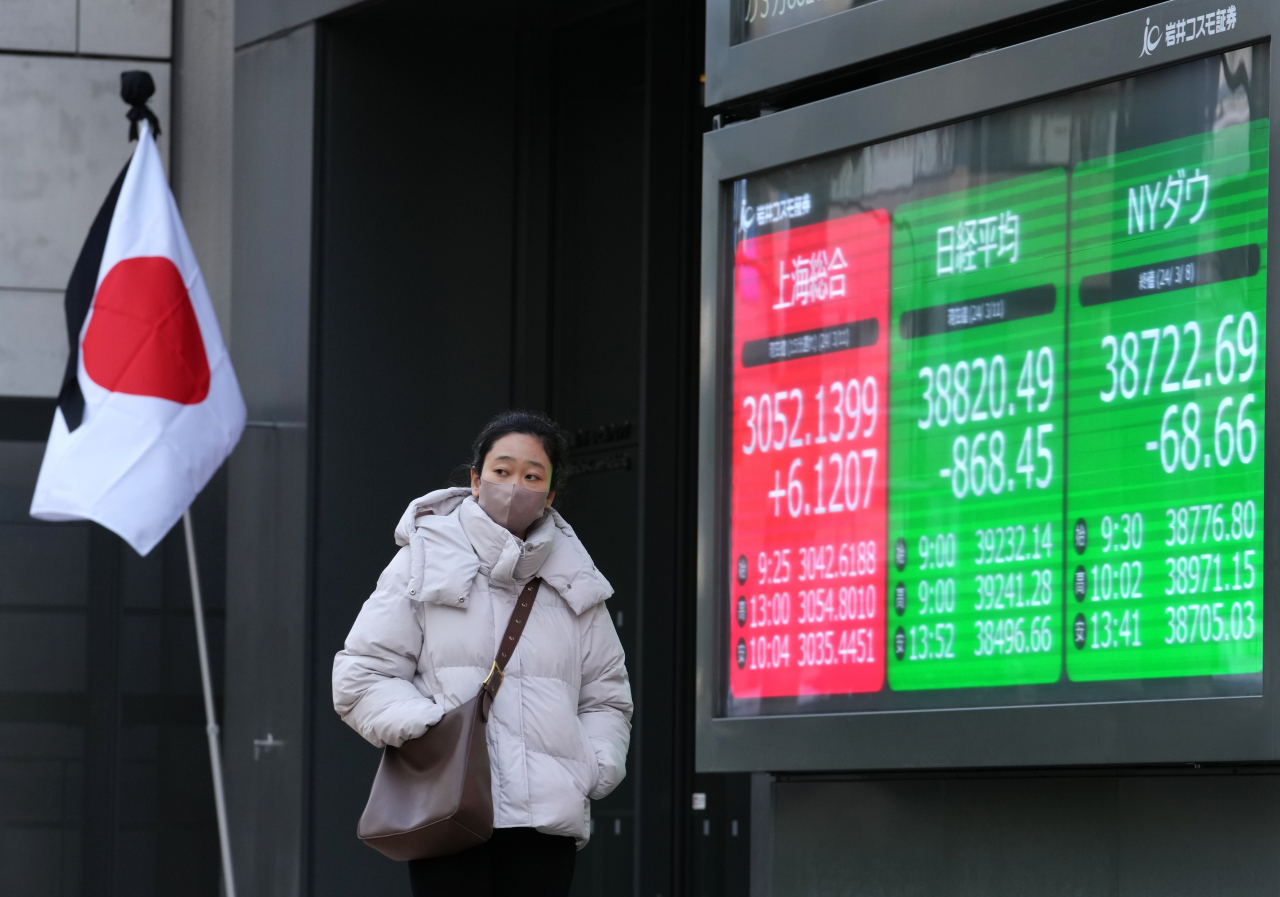 11일 일본 도쿄에서 한 시민이 닛케이225평균지수를 보여주는 차트를 지나가고 있다. [EPA]