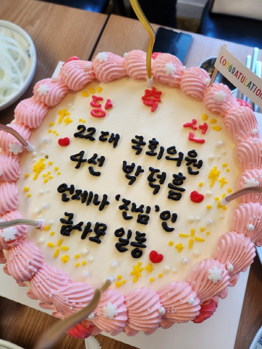 국민의힘 박덕흠 예비후보의 지지모임인 '금사모'가 22대 당선을 축하한다는 문구를 적어 놓은 케이크. [동양일보 제공]