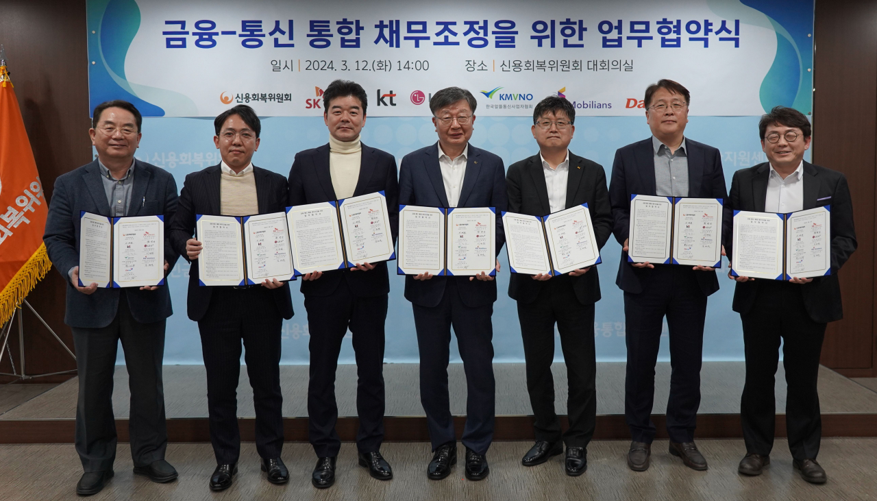 신용회복위원회와 통신업계가 통합 채무조정을 위한 협약에 나섰다. 황성욱(왼쪽부터) 한국알뜰통신사업자협회 부회장, 이동춘 다날 상무, 남태욱 KG모빌리언스 이사, 이재연 신용회복위원회 위원장, 박철호 KT 상무, 권영상 SKT 부회장, 이규화 LGU+ 상무. [신용회복위원회 제공]