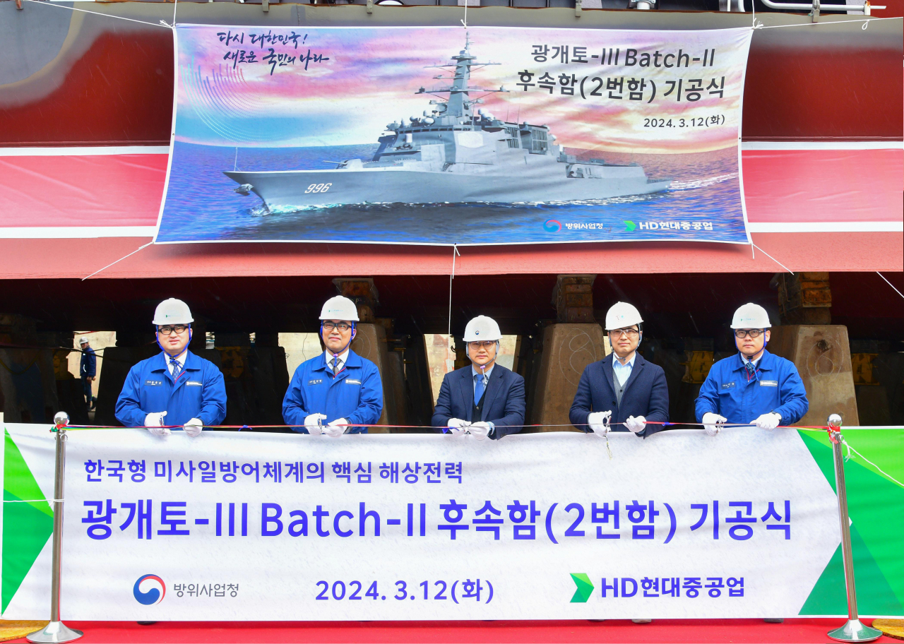 송운성(왼쪽부터) HD현대중공업 특수선사업지원담당 상무와 김상철 특수선생산담당 상무, 이수용 방위사업청 함정사업부 팀장, 이지혁 국방기술품질원 선임연구원, 이광용 HD현대중공업 특수선의장생산 담당 수석이 12일 울산 조선소 특수선 야드에서 열린 차세대 이지스 구축함 2번함 기공식에서 기념촬영을 하고 있다. [HD현대중공업 제공]