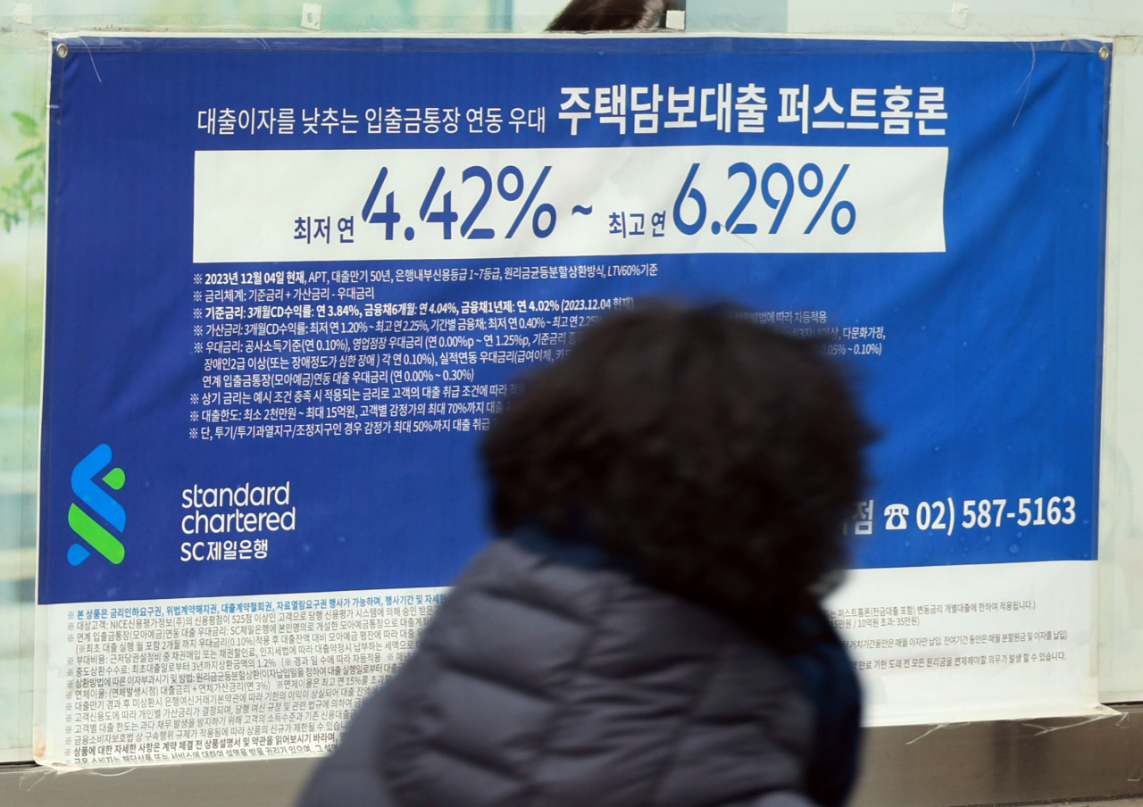 서울 한 시중은행 영업점의 대출 안내문 앞을 시민이 지나가고 있다.[연합]
