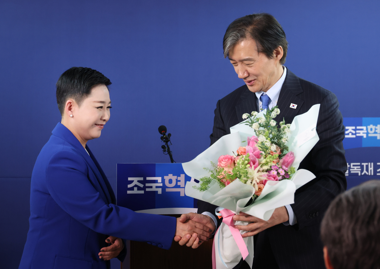 가수 리아(본명 김재원)가 11일 여의도 조국혁신당 당사에서 열린 입당 환영식에서 조국 대표로부터 꽃다발을 받고 있다. [연합]