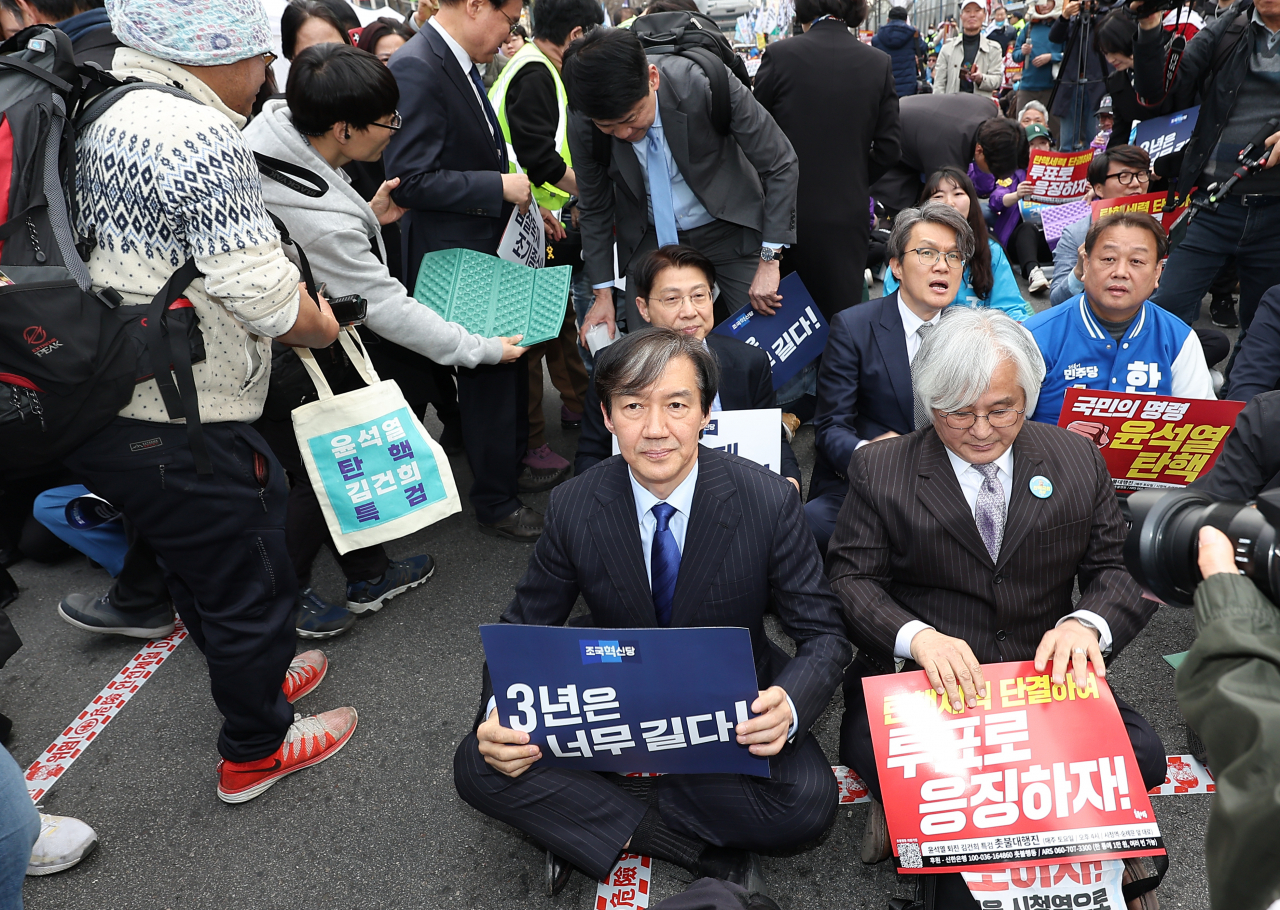 조국 조국혁신당 대표(가운데)가 지난 16일 오후 서울 중구 서울시청 인근에서 열린 전국집중촛불 81차 촛불대행진에서 자리에 앉고 있다. [연합]