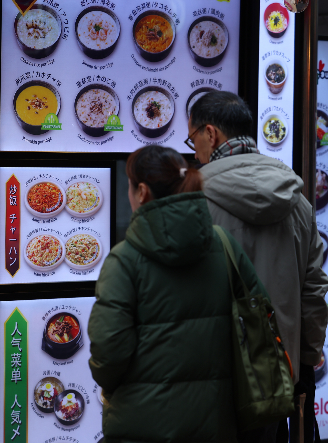 서울 중구 명동의 한 음식점 앞에서 관광객들이 메뉴를 살피고 있다. [연합]
