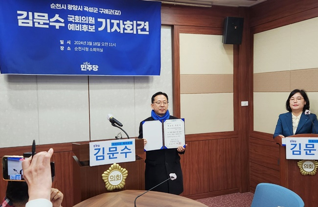'순천갑' 공천자로 확장된 민주당 김문수 후보가 18일 공천장을 들고 사진 촬영에 응하고 있다.