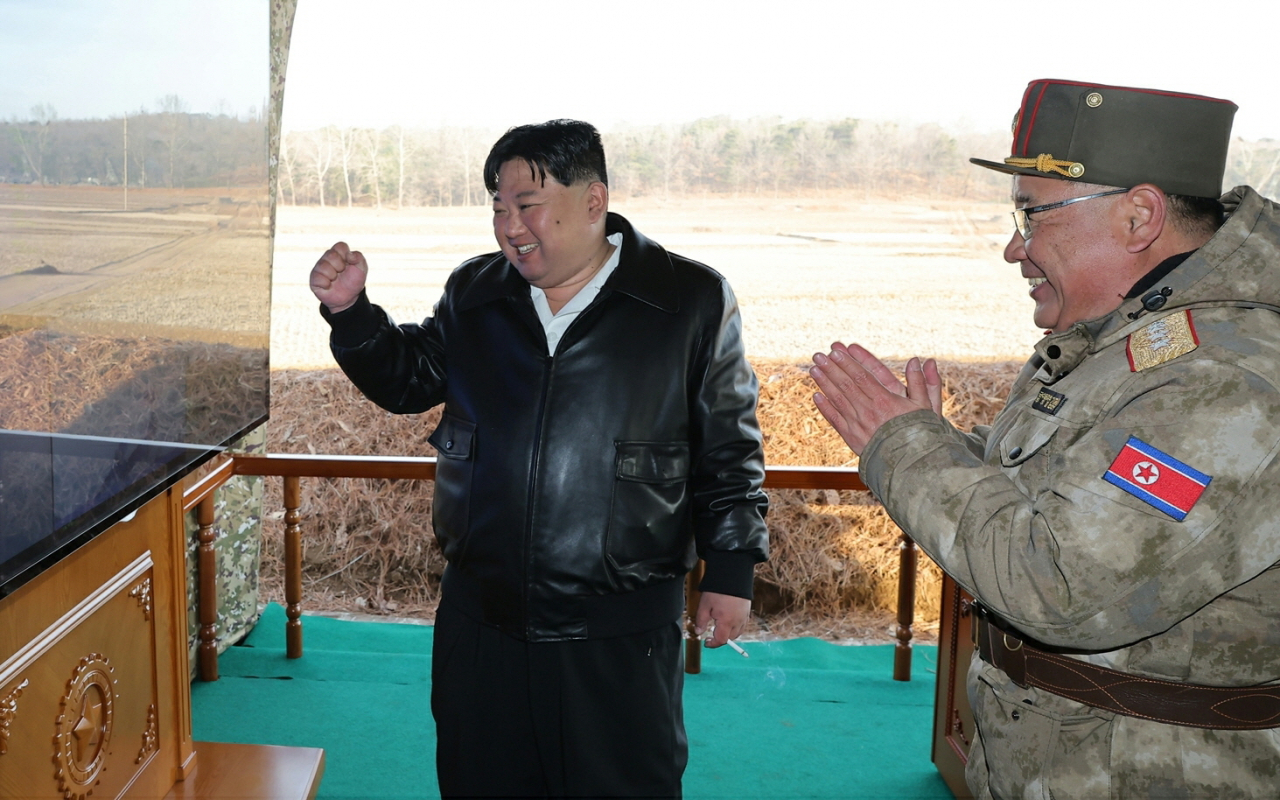 북한 노동당 기관지 노동신문은 김정은 국무위원장이 전날 초대형방사포 KN-25 사격훈련을 지도했다고 19일 보도했다. 김 위원장이 사격훈련을 지켜보며 만족스러운 듯 오른손 주먹을 쥐고 밝은 표정을 짓고 있다. [평양 노동신문=뉴스1]
