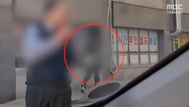 18일 이날 오전 경기 김포의 한 아파트에서 흉기에 찔려 도움을 요청하는 경비원 뒤로 가해 남성(70대)이 유유히 현장을 빠져나가는 모습. [MBC 보도화면 캡처]
