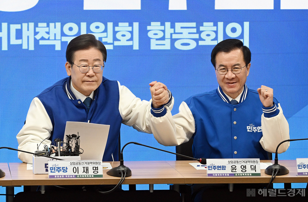 이재명 더불어민주당 상임공동선대위원장(왼쪽)과 윤영덕 더불어민주연합 상임공동선대위원장이 20일 오전 서울 여의도 중앙당사에서 열린 더불어민주당·더불어민주연합 중앙선거대책위원회 합동회의에서 손을 맞잡고 있다. 이상섭 기자
