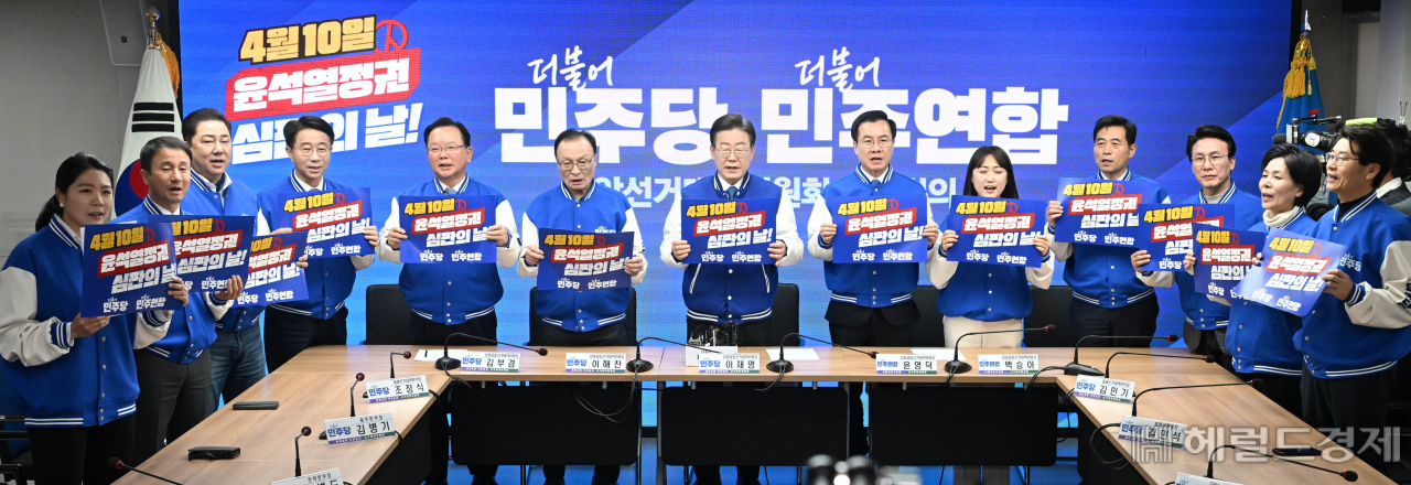 이재명 더불어민주당 상임공동선대위원장을 비롯한 참석자들이 20일 오전 서울 여의도 중앙당사에서 열린 더불어민주당·더불어민주연합 중앙선거대책위원회 합동회의에 참석해 윤석열 정권을 심판하자는 피켓 퍼포먼스를 하고 있다. 이상섭 기자