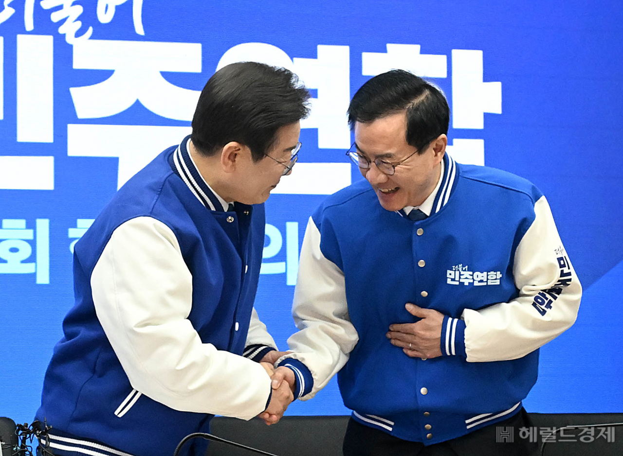 이재명 더불어민주당 상임공동선대위원장(왼쪽)과 윤영덕 더불어민주연합 상임공동선대위원장이 20일 오전 서울 여의도 중앙당사에서 열린 더불어민주당·더불어민주연합 중앙선거대책위원회 합동회의에서 악수를 하고 있다. 이상섭 기자