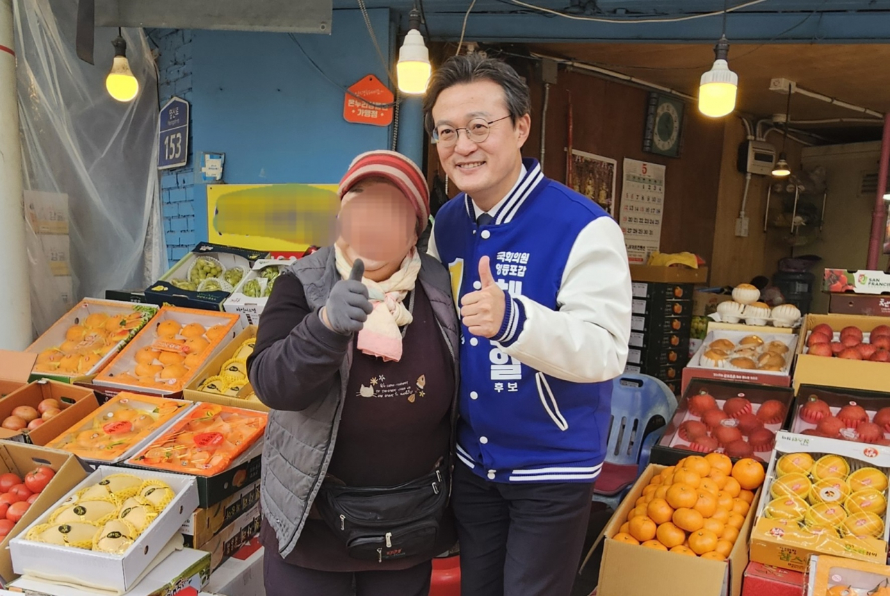 채현일 더불어민주당 서을 영등포갑 예비후보가 19일 영등포시장에서 한 상인과 기념촬영을 하고 있다. [박지영 기자]