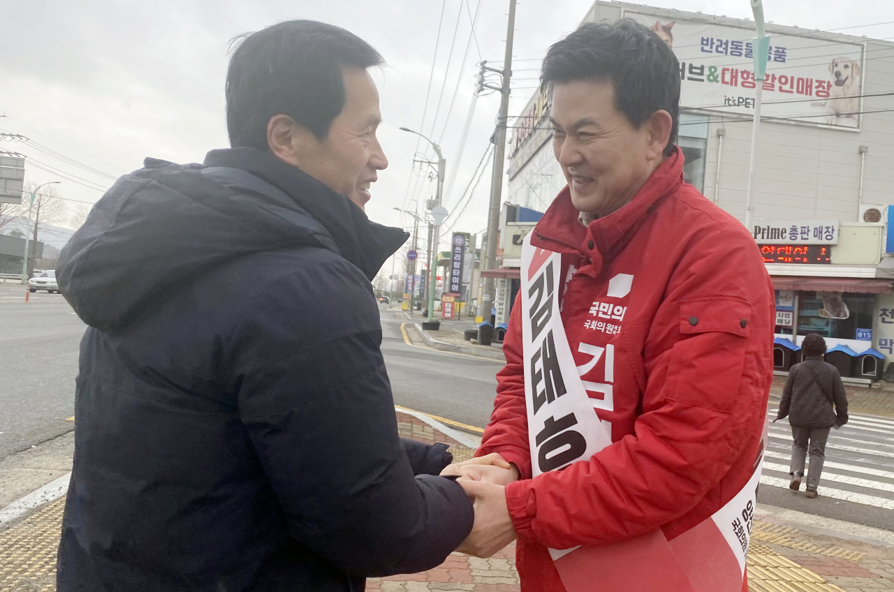 제22대 총선 경남 양산을 선거구에 출마한 국민의힘 김태호 후보가 7일 아침 양산시 덕계사거리에서 출근하는 한 시민 손을 잡고 인사하고 있다. [연합]