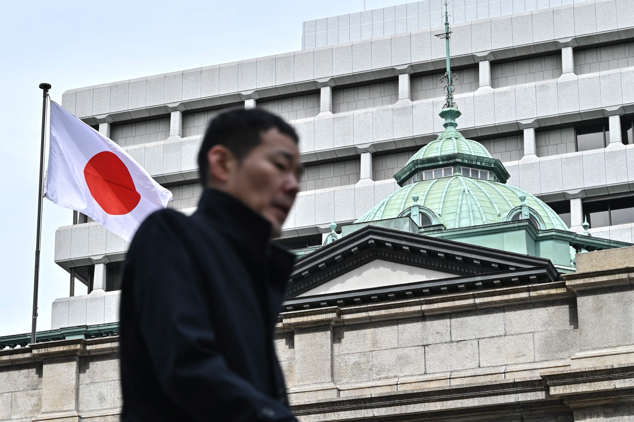 19일 일본 도쿄에서 한 남성이 일본은행(BOJ) 본사를 지나가고 있다. 일본은행은 이날 금융정책결정회의를 열고 단기 정책금리(무담보 콜금리)를 0&sim;0.1%로 유도하기로 결정했다. [AFP]