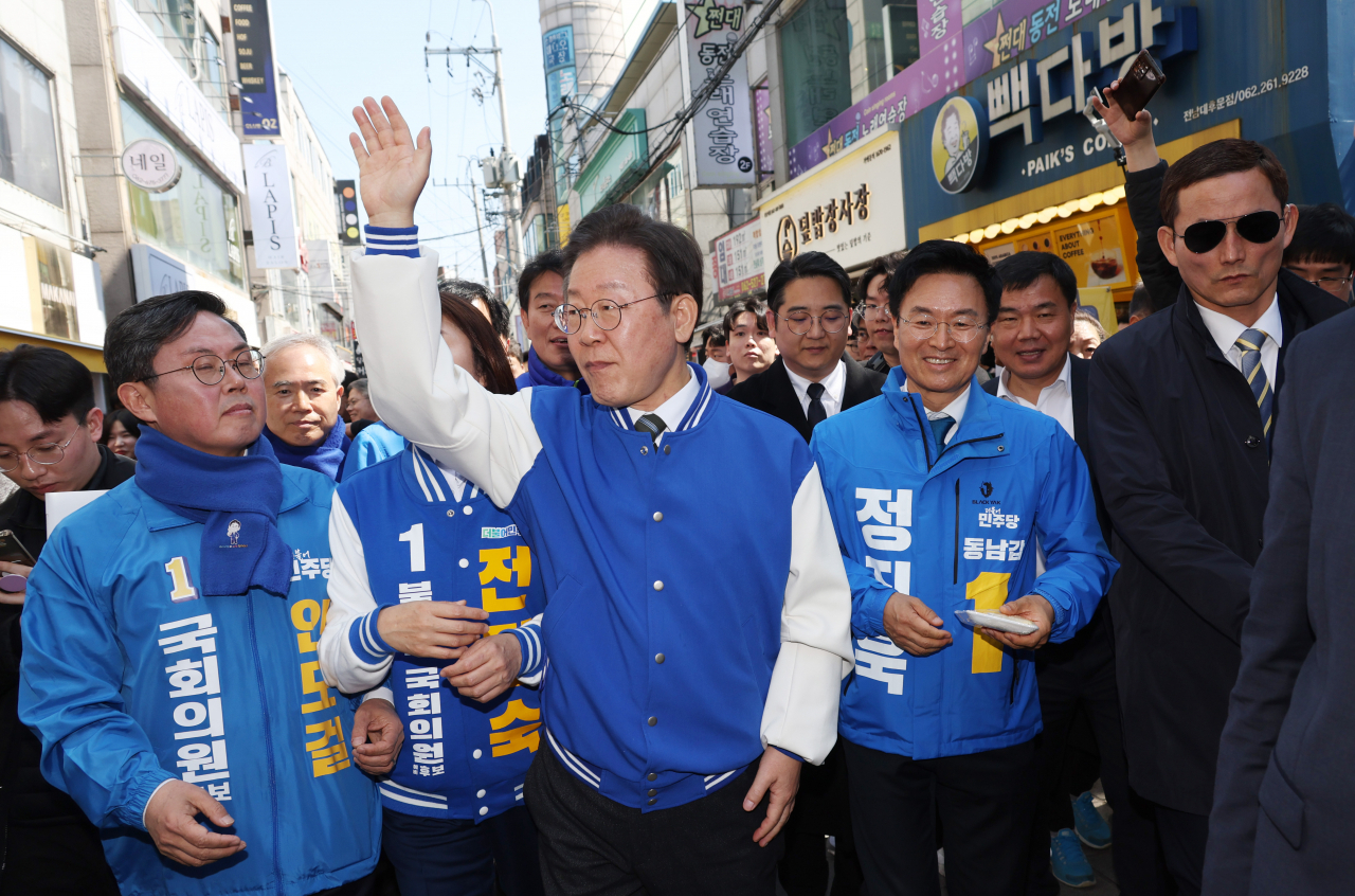 이재명(가운데) 더불어민주당 대표가 21일 광주 전남대 후문 상가 밀집지역을 방문해 이 지역에 출마한 후보들과 함께 거리 인사를 하고 있다. [연합]