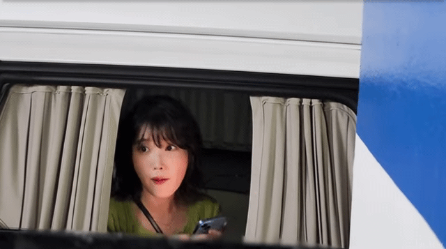 아이유가 퇴근길에 만난 팬들에게 아이폰의 ‘에어드랍’ 기능으로 자신의 셀카를 공유하는 모습. 한 팬이 "갤럭시를 쓴다"고 말하자, 아이유가 "미안해요"라고 말하며 멋쩍게 웃는 모습이 담겼다. [유튜브(ForYou) 갈무리]