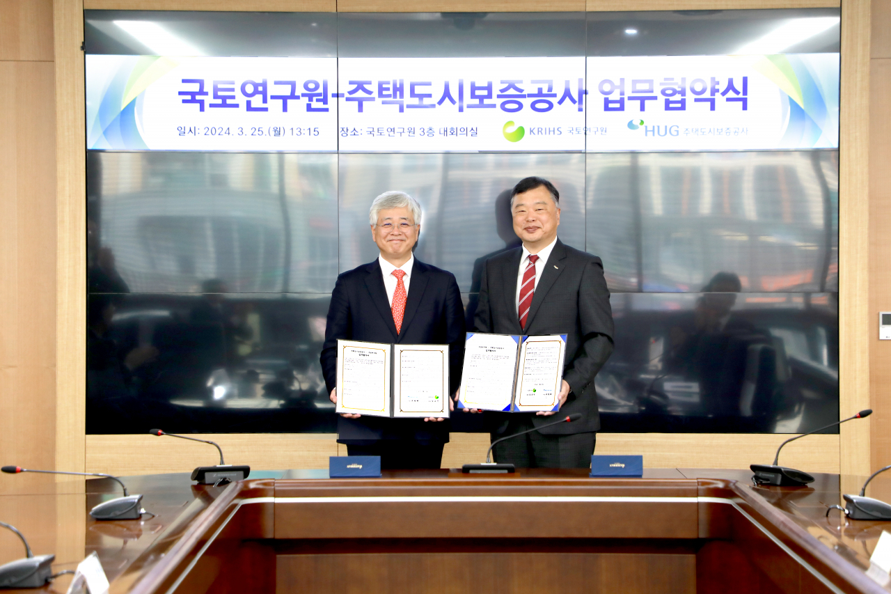 심교언 국토연구원장과 유병태 HUG 사장(오른쪽)이 25일 세종시 국토연구원에서 진행한 업무협약식 이후 기념사진을 찍고 있다. [주택도시보증공사]