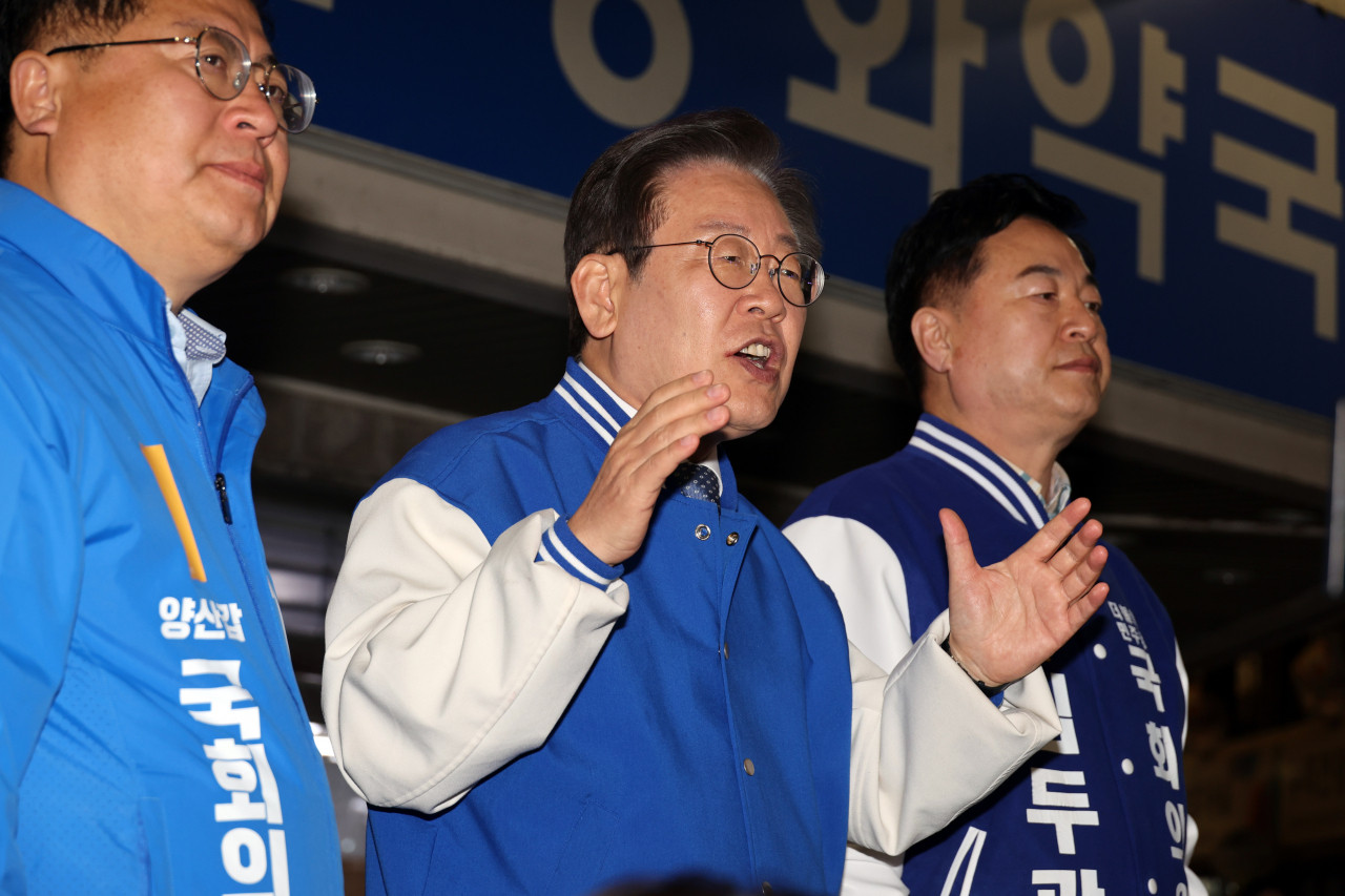 더불어민주당 이재명 대표가 25일 오후 경남 양산시 남부시장에서 양산갑 이재영 후보(왼쪽), 양산을 김두관 후보와 함께 지지를 호소하며 외치고 있다. [연합]