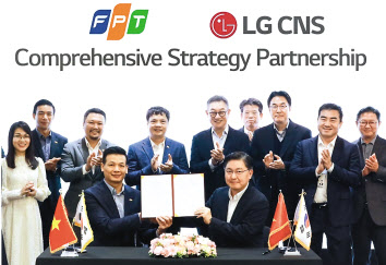 현신균(뒷줄 오른쪽 다섯 번째) LG CNS 대표와 응우옌 반 코아(뒷줄 왼쪽 네 번째) FPT그룹 CEO 등 관계자가 참석한 가운데 박상균 LG CNS 통신·유통·서비스사업부장(전무)과 부 아잉 뚜 FPT그룹 CTO가 업무협약(MOU)을 체결하고 있다. [LG CNS 제공]