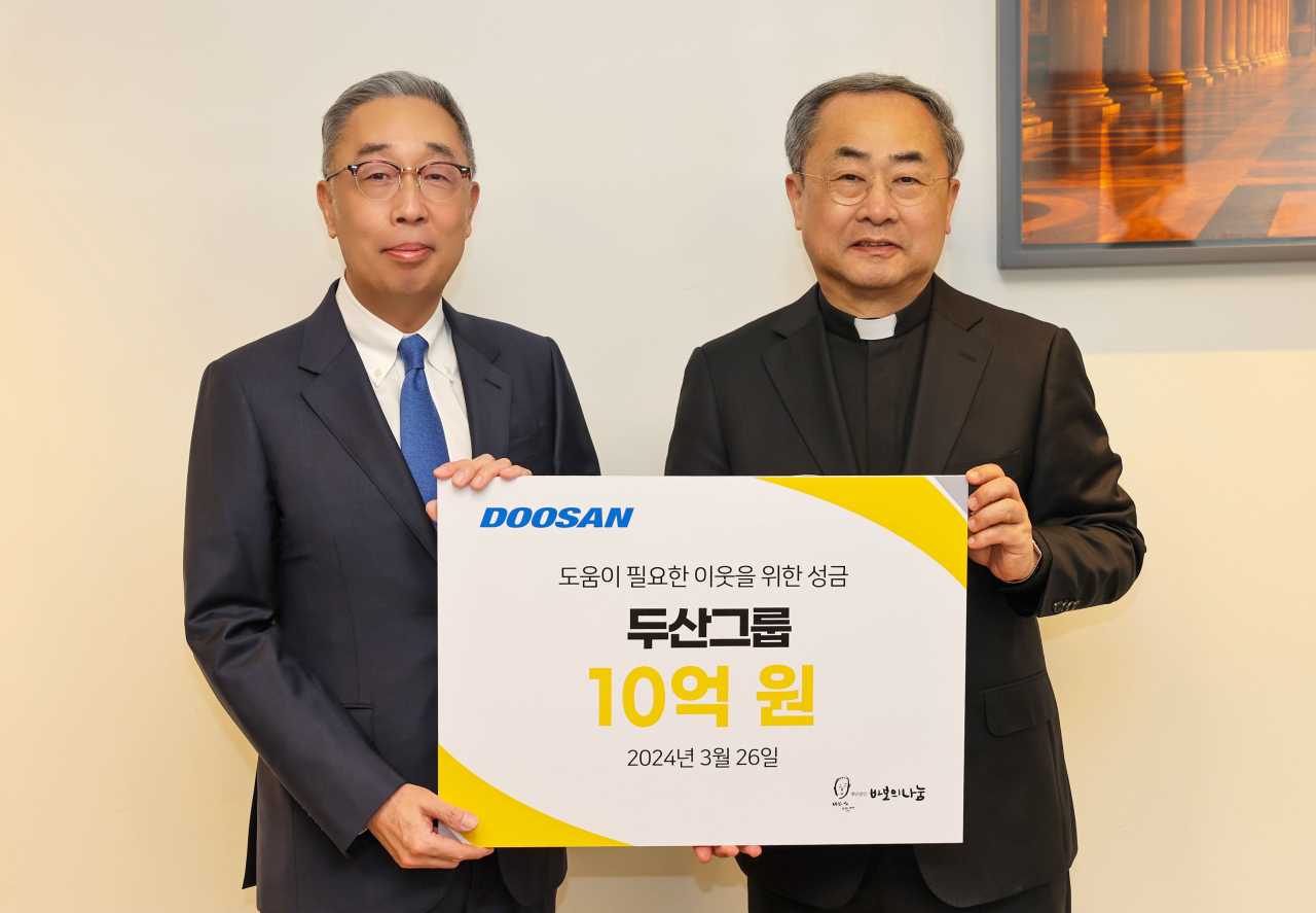 박지원(왼쪽) 두산그룹 부회장, 손희송 재단법인 바보의 나눔 이사장이 성금 전달식에서 기념촬영을 하고 있다. [두산 제공]