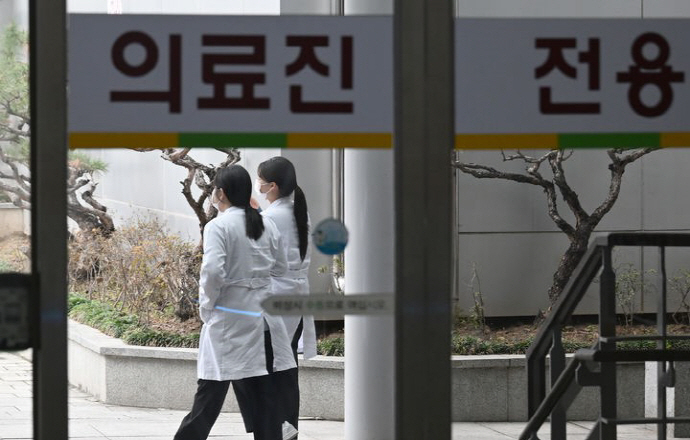 의과대학 정원 증원에 반발한 의대 교수들이 집단 사직에 돌입하는 등 의정갈등이 심화되고 있는 26일 광주 동구 전남대병원 에서 의료진이 이동하고 있다.[뉴시스]