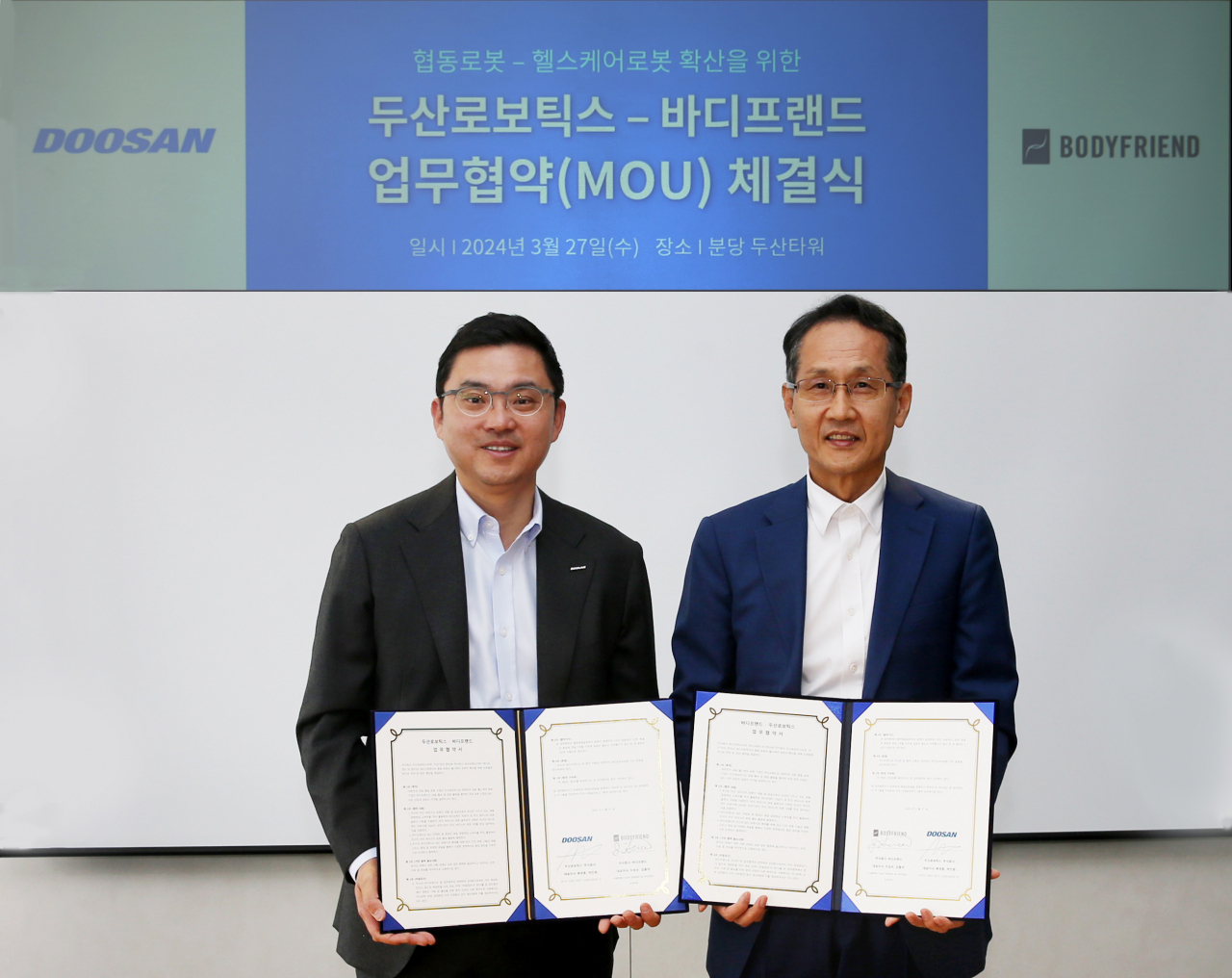 류정훈(왼쪽) 두산로보틱스 대표와 지성규 바디프랜드 대표가 27일 ‘헬스케어로봇과 협동로봇 확산’을 위한 업무협약을 체결한 뒤 기념촬영을 하고 있다. [두산로보틱스 제공]