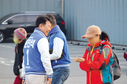 문진석 충남 천안갑 더불어민주당 후보가 시민과 인사를 나누고 있다(왼쪽). 신범철 충남 천안갑 국민의힘 후보가 시장에서 상인에게 인사를 건네고 있다.  [문진석 후보 캠프 제공]·박지영 기자