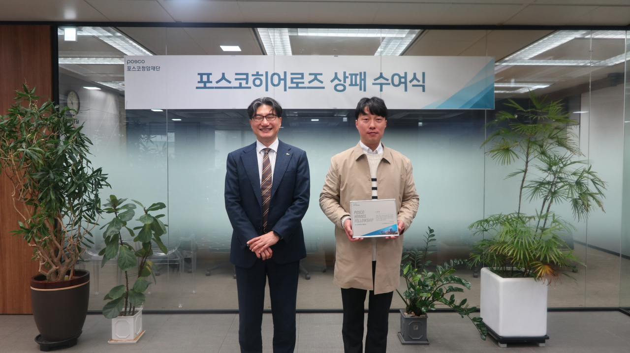 26일 포스코센터에서 포스코청암재단이 흉기 난동범을 제압한 조갑현 씨(오른쪽)에게 상패와 자녀 장학금을 전달하고 기념사진을 촬영하고 있다. [포스코 제공]