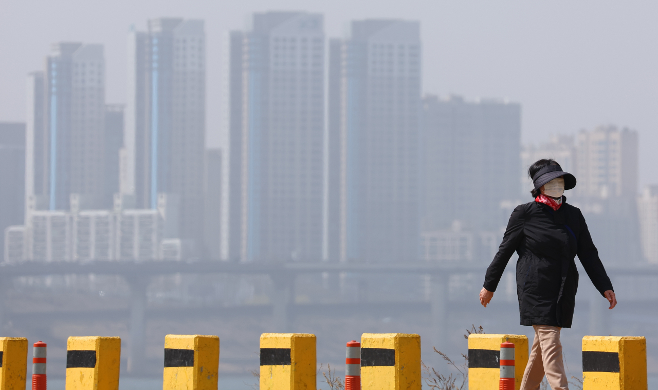 This March 17, 2024, file photo shows a pedestrian wearing a mask in Seoul when a yellow dust advisory was in place. (Yonhap)