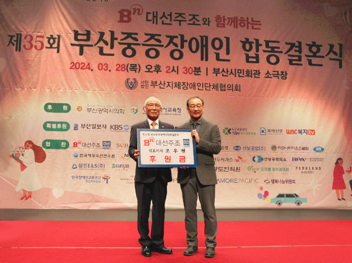 차재영 대선주조 상무(오른쪽)가 유영호 부산지체장애인단체협의회장에게 후원금을 전달하고 있다. [사진=대선주조]