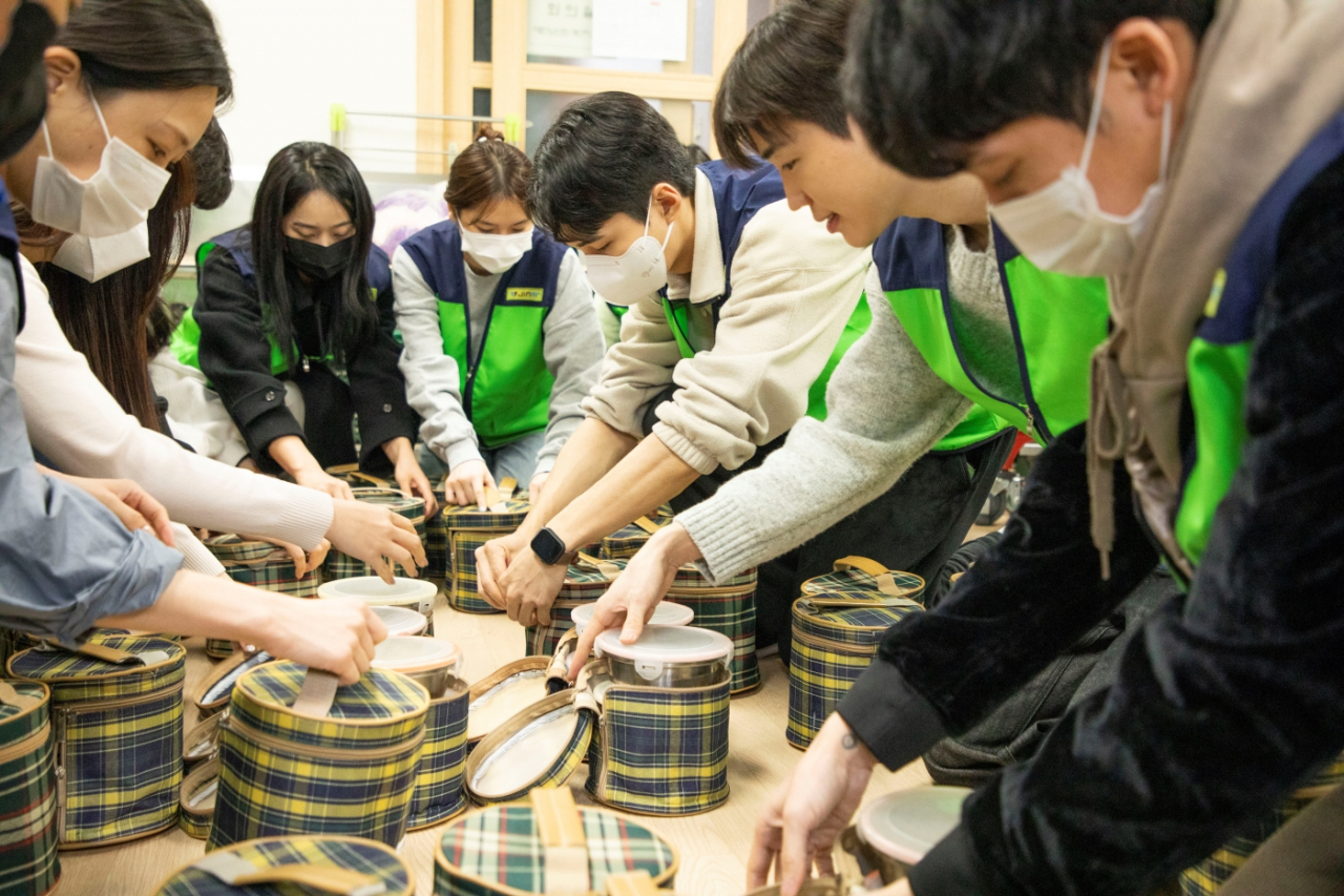 도시락 배달 봉사 활동에 참여한 진에어 임직원들이 도시락을 포장하는 모습. [진에어 제공]