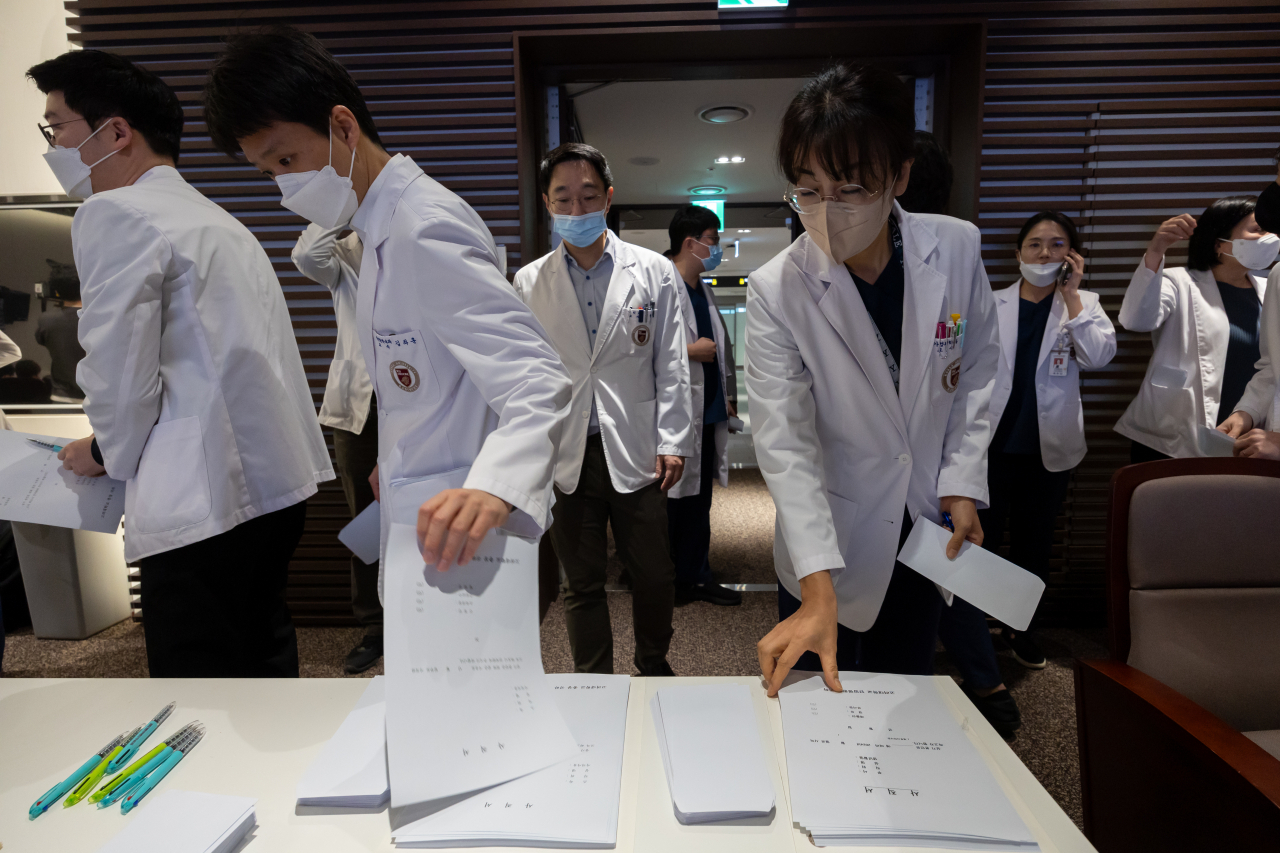 25일 오전 서울 고려대학교 안암병원에서 열린 ‘고려대학교 의료원 교수 총회’에 참석한 교수들이 사직서 가져가고 있다.[연합]