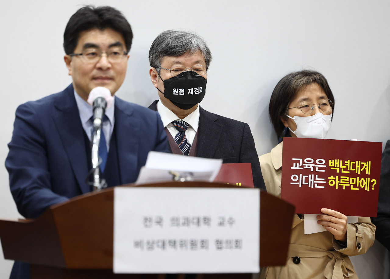 30일 오전 서울 종로구 서울대학교병원에서 열린 전국의대교수비상대책위원회 협의회 기자회견에서 참석 교수들이 의대 증원 정책에 반발하는 손팻말을 들고 있다. [연합]