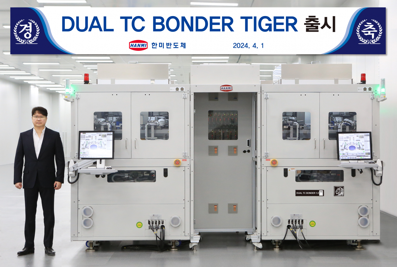 곽동신(왼쪽) 한미반도체 부회장과 HBM 필수공정 장비 ‘듀얼 TC본더 타이거’. [한미반도체 제공]