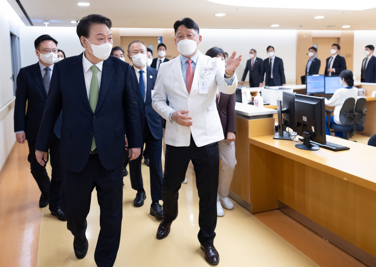 윤석열 대통령이 1일 대전 유성구 유성선병원을 찾아 병원장과 함께 수술 참관실로 이동하고 있다. [연합]