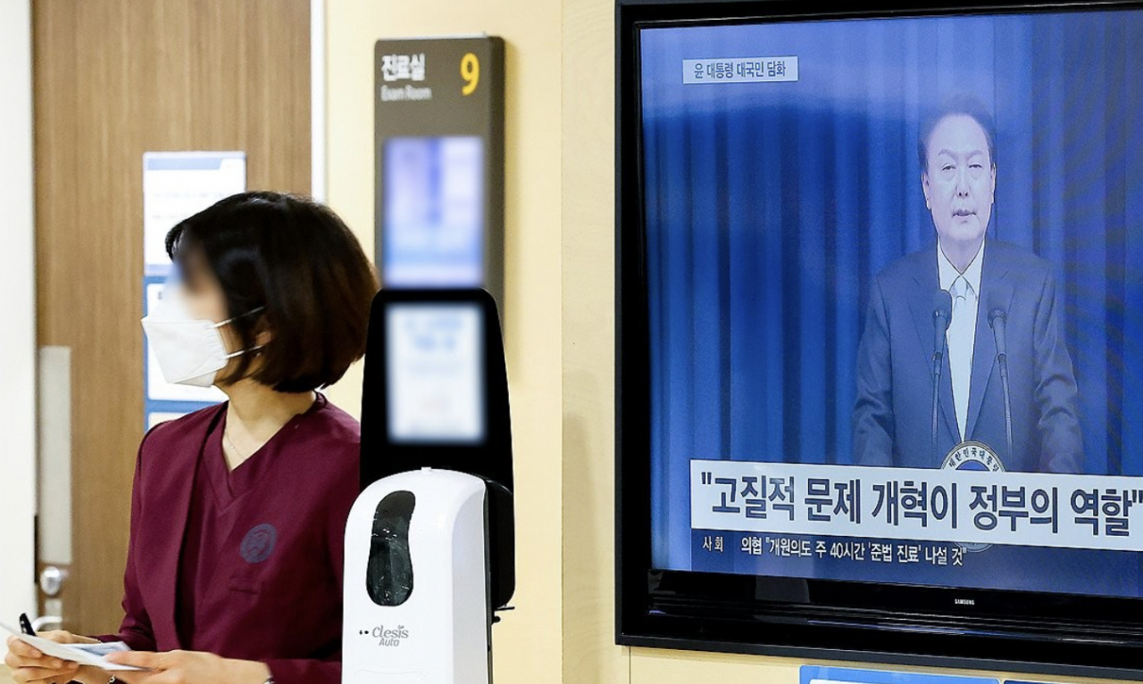 1일 오전 서울 한 대형병원에서 한 의료 관계자가 윤석열 대통령의 의료 개혁 관련 대국민 담화를 지나치고 있다. [연합]
