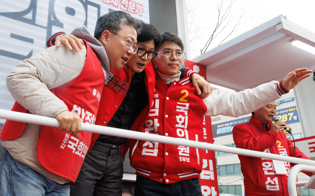 한동훈 국민의힘 비상대책위원장 겸 총괄선대위원장이 3일 강원도 원주 롯데시네마 인근에서 열린 집중 유세에서 박정하(강원 원주시갑) 후보, 김완섭(강원 원주시을) 후보와 어깨동무하고 있다. [연합]