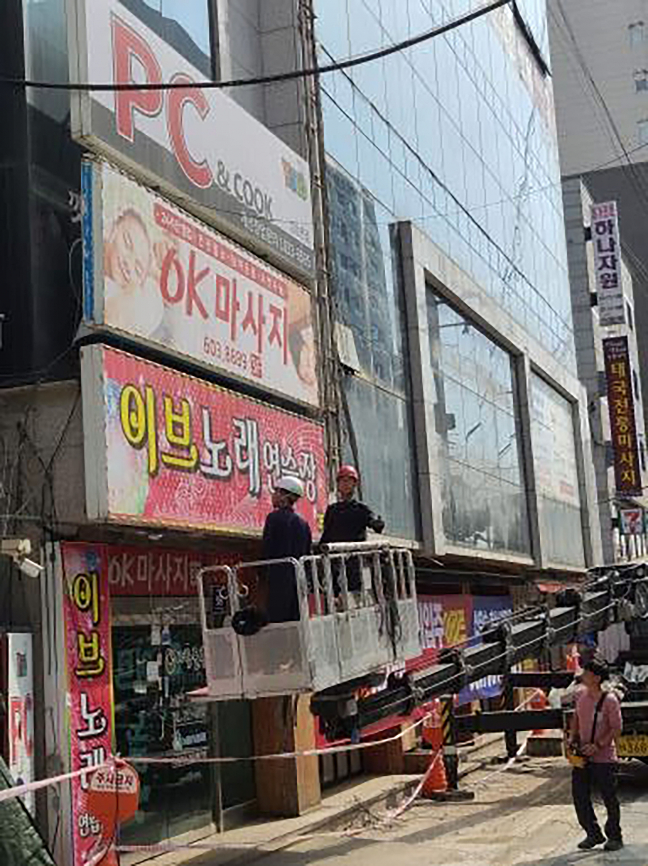 성남시 관계자들이 중원구 한 건물의 주인없는 간판을 정비하고 있다.[성남시 제공]