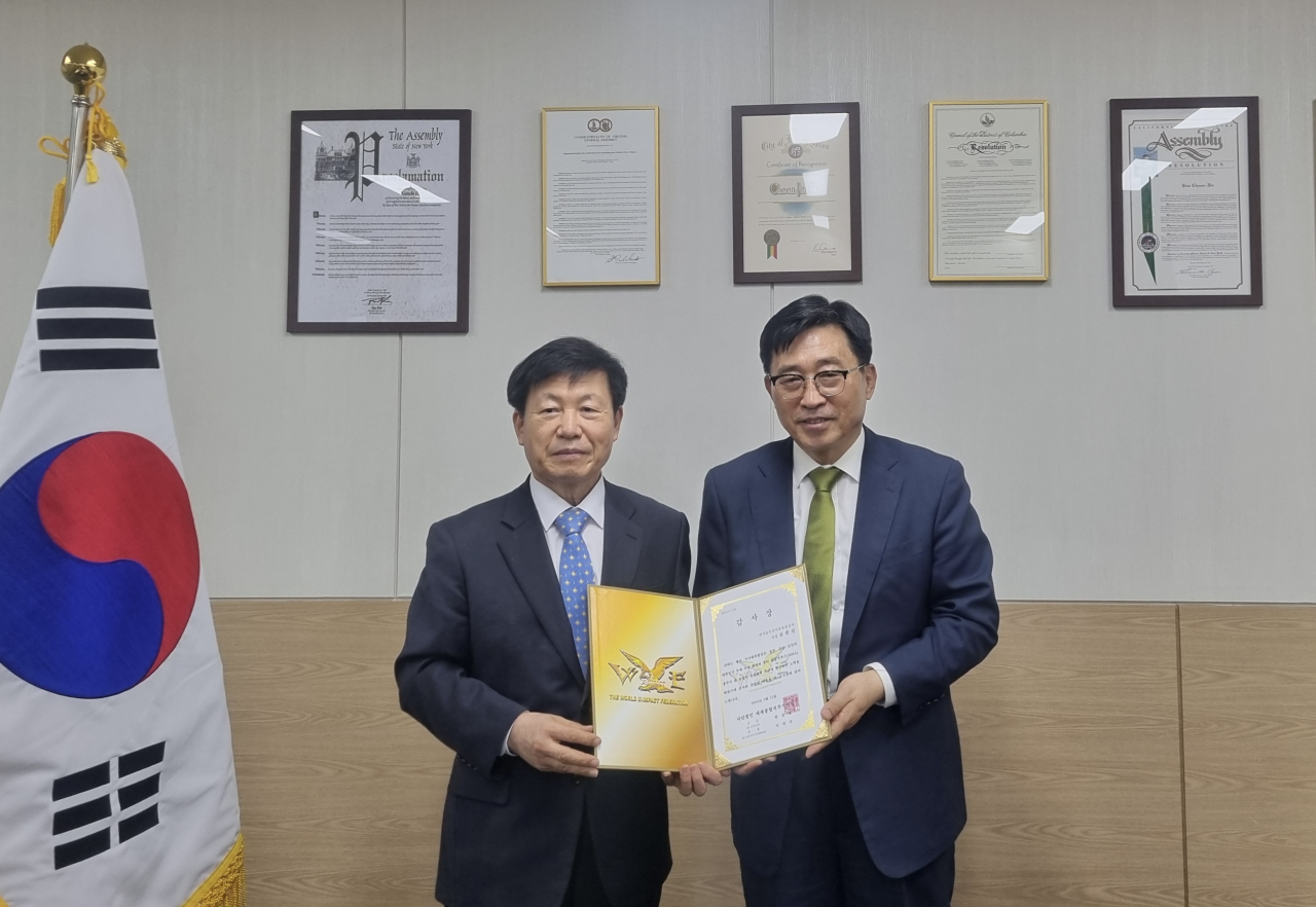 김춘진(오른쪽) 한국농수산식품유통공사 사장이 4일 서울 서초구 양재동 aT센터에서 국가 체육 발전 공로로 (사)세계종합격투기연맹 이각수 총재로부터 감사장을 받고 기념촬영을 하고 있다.[한국농수산식품유통공사 제공]