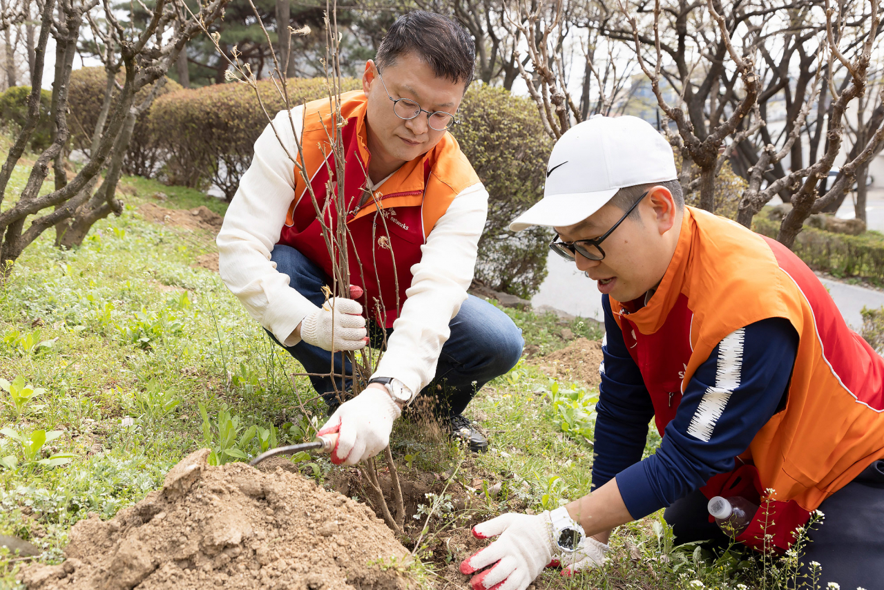 지난 5일 식목일을 맞아 남산공원에서 무궁화 묘목 식재 활동 중인 이호정 SK네트웍스 대표이사 사장과 구성원들의 모습. [SK네트웍스 제공]