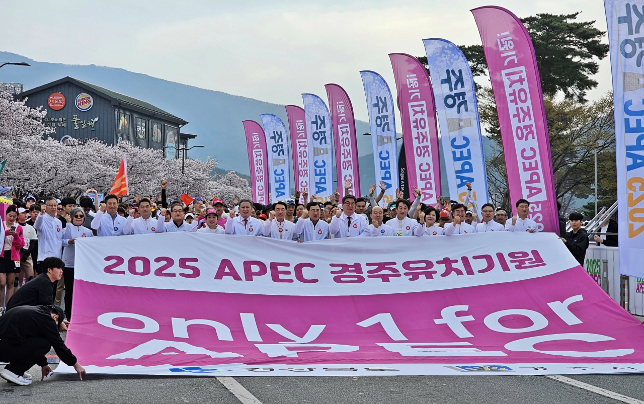'제31회 경주벚꽃마라톤대회'에 참가한 시민과 관광객들이 2025 APEC 경주유치기원 퍼포먼스를 하고 있다.[경주시 제공]