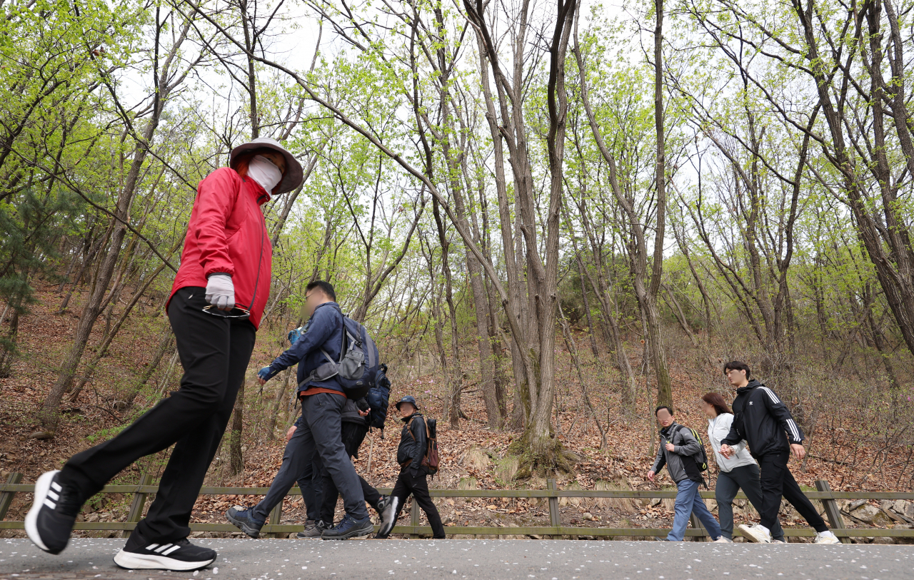 People walk in Gwanaksan in Seoul on Wednesday. The mountain, stretching across southern Seoul and Gyeonggi Province, is famous for its hiking paths that can be approached via multiple subway stations in Seoul, Anyang and Gwancheon. (Yonhap)