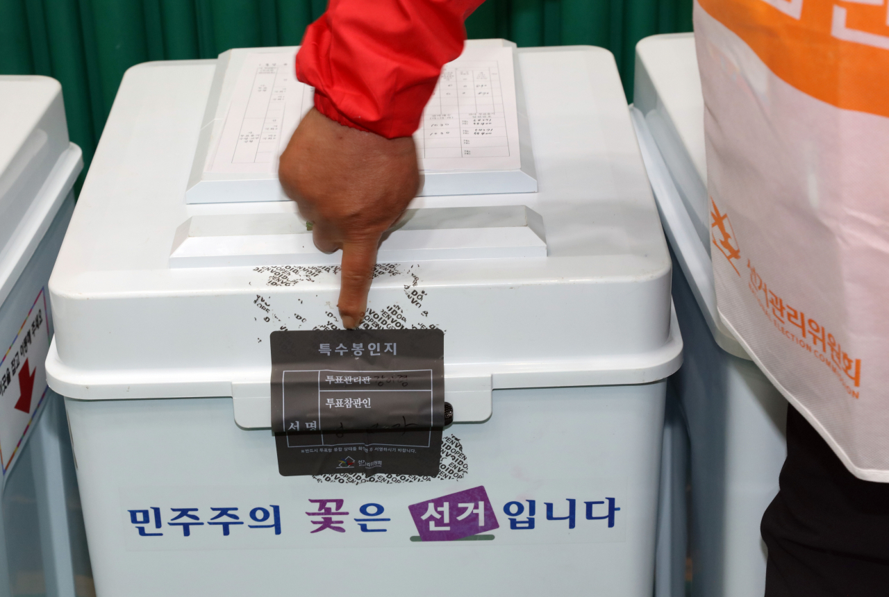 제22대 국회의원 선거 제주 서귀포시 지역구 개표장인 올림픽기념국민생활관에서 한 개표 참관인이 봉인 흔적이 남아 있는 개표함을 가리키고 있다. [연합]