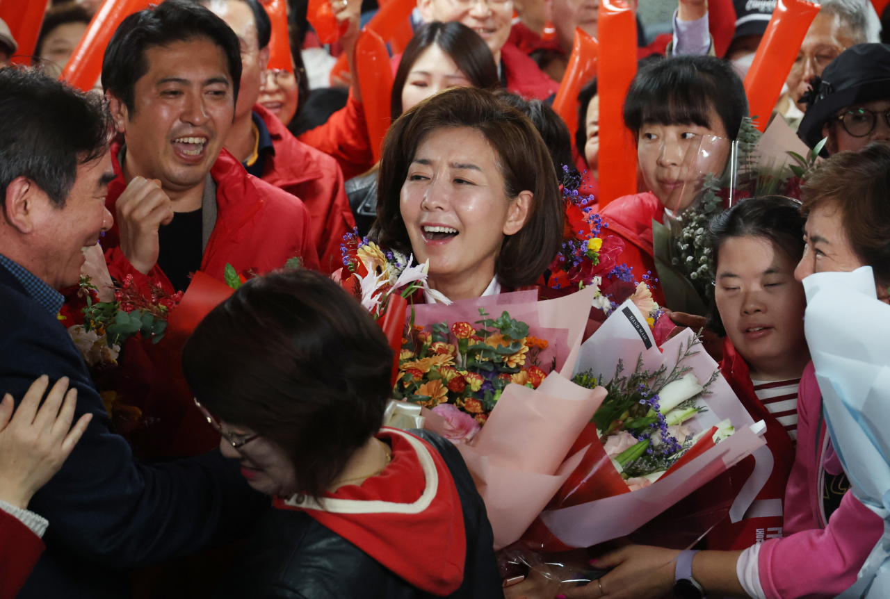 서울 동작을에서 당선이 확실해진 나경원 국민의힘 후보가 11일 동작구 선거사무소에서 꽃다발을 받고 있다. [연합]